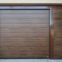 Garážová brána ISO brány vo farbe Orech stredový prelis - Woodgrain namontovná na železnom ráme s bočnými dverami a pevným panelom.jpg